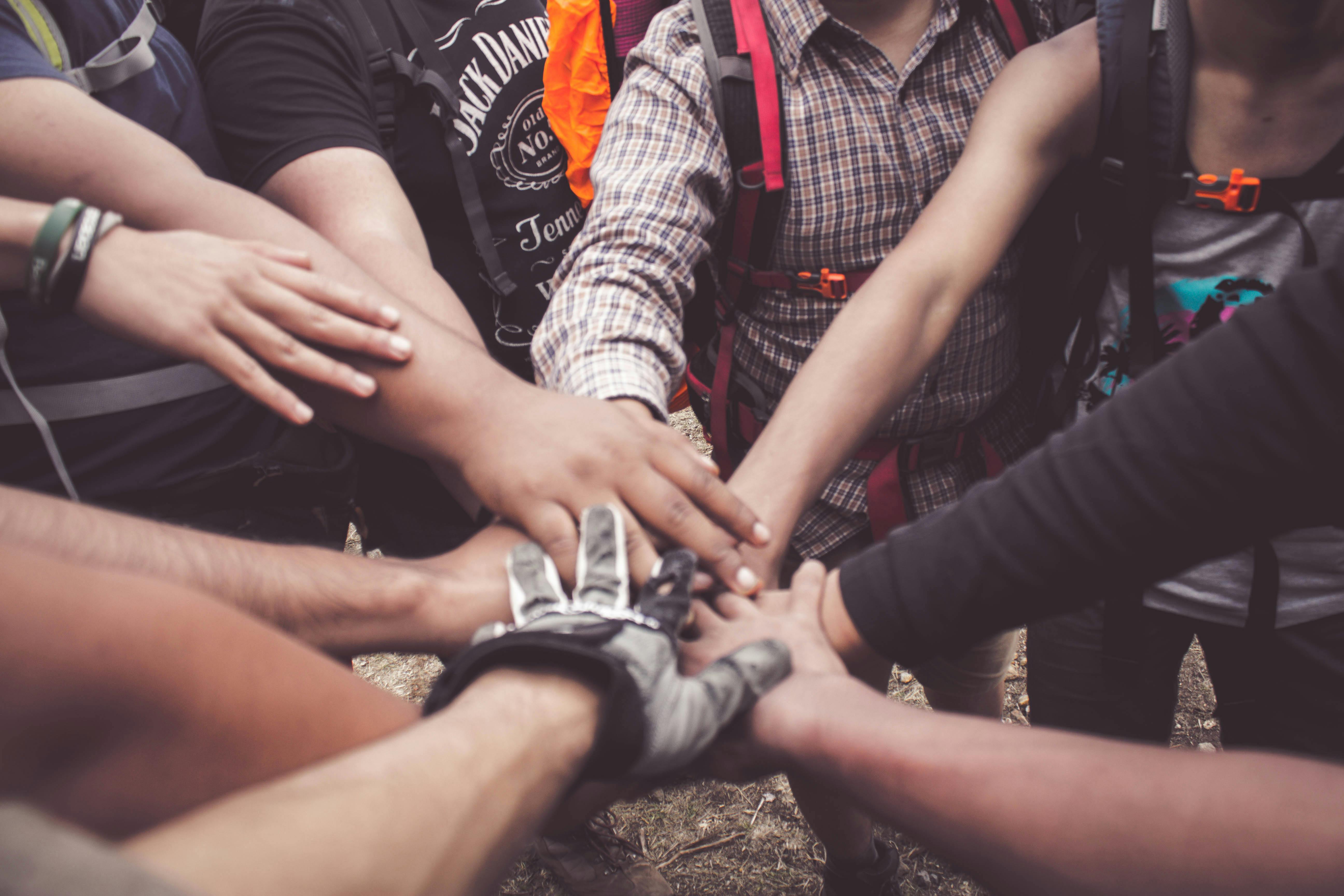 Diverse group of people joining hands together — collective action and shared purpose